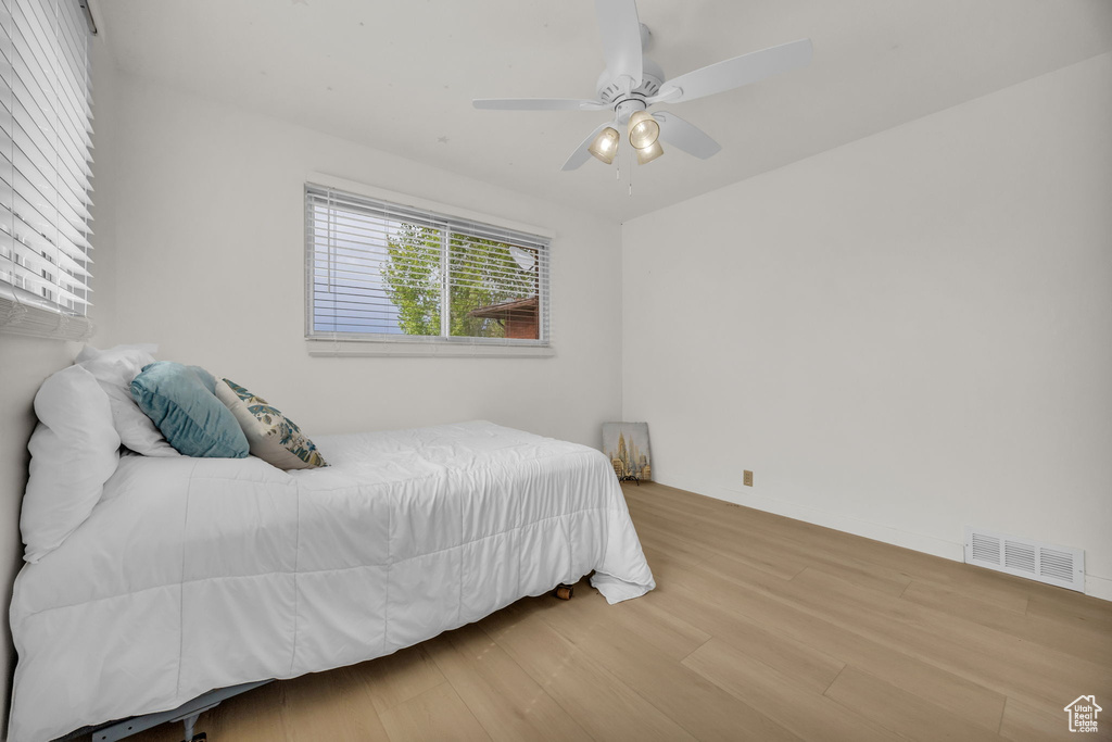 Bedroom with visible vents, ceiling fan, and wood finished floors