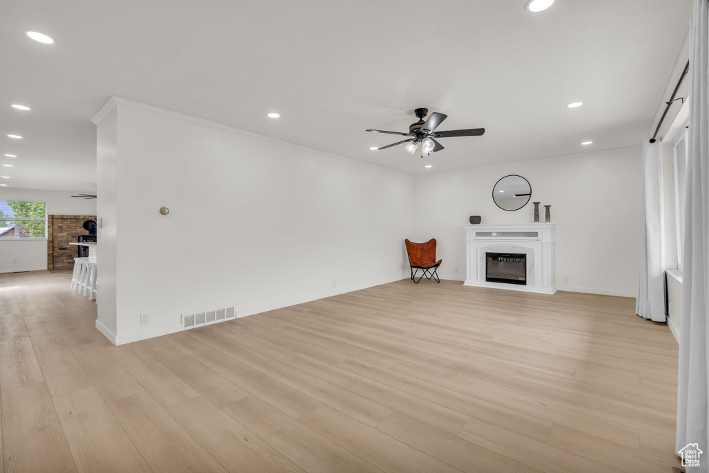 Unfurnished living room with a glass covered fireplace, a ceiling fan, recessed lighting, and visible vents