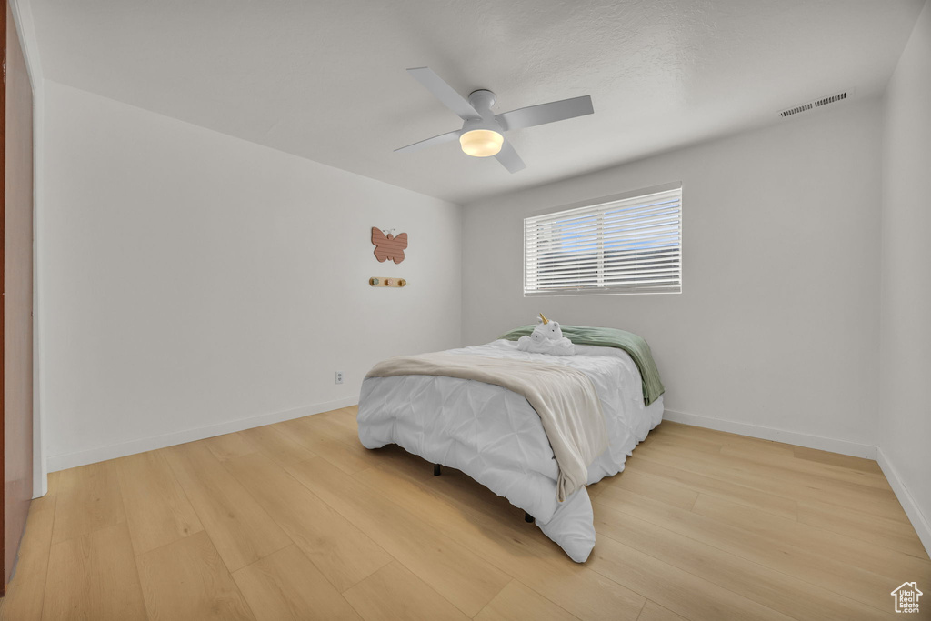 Bedroom with a ceiling fan, baseboards, visible vents, and light wood-style floors