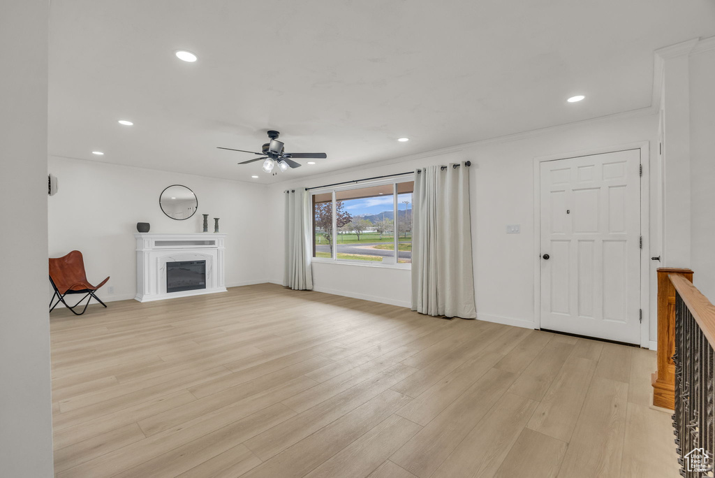 Unfurnished living room with recessed lighting, ceiling fan, and a glass covered fireplace