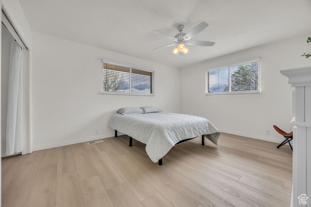 Bedroom with visible vents, a closet, baseboards, light wood-type flooring, and a ceiling fan