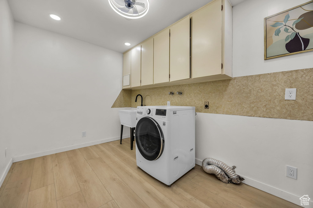 Clothes washing area featuring light wood-style floors, cabinet space, recessed lighting, and washer / clothes dryer
