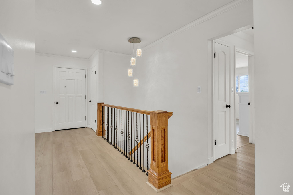 Corridor featuring crown molding, wood finished floors, baseboards, an upstairs landing, and recessed lighting