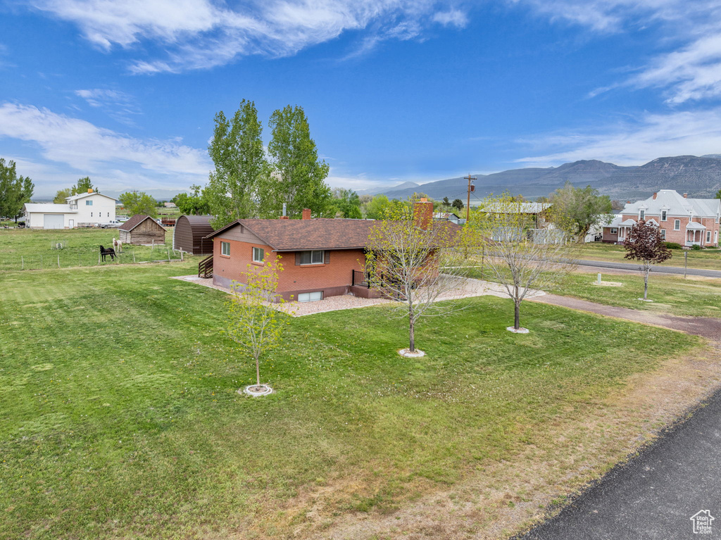 View of front of home featuring a front lawn, a mountain view, and a chimney