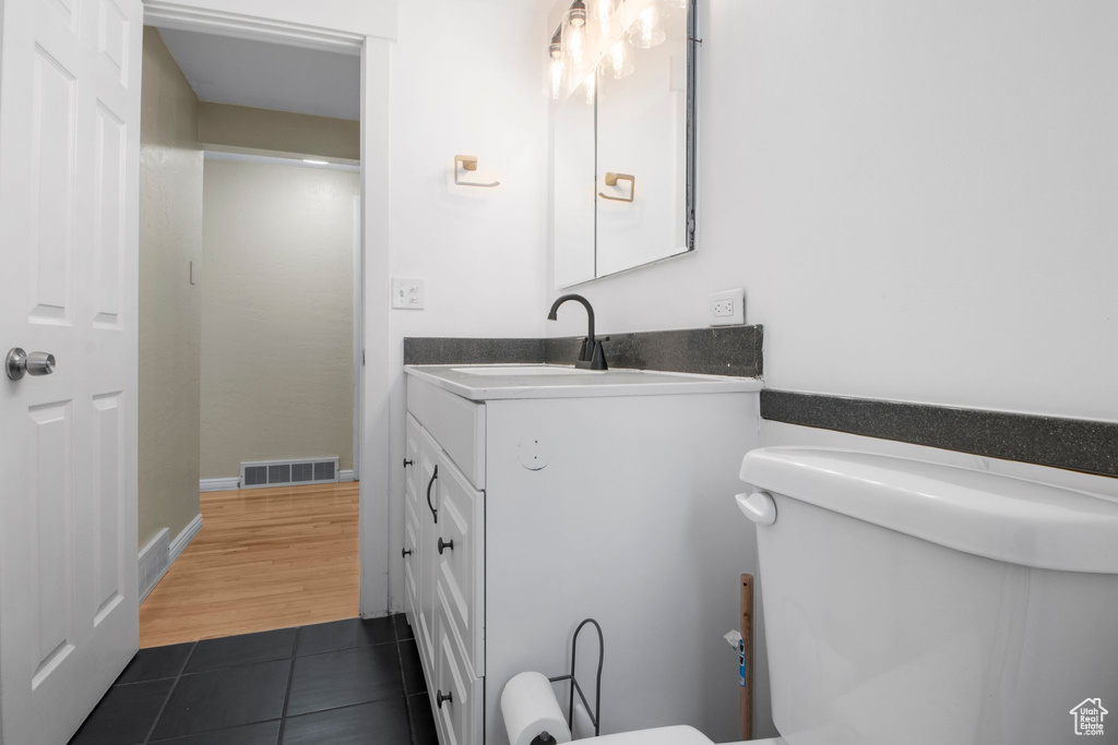 Bathroom with tile patterned floors, vanity, toilet, and visible vents
