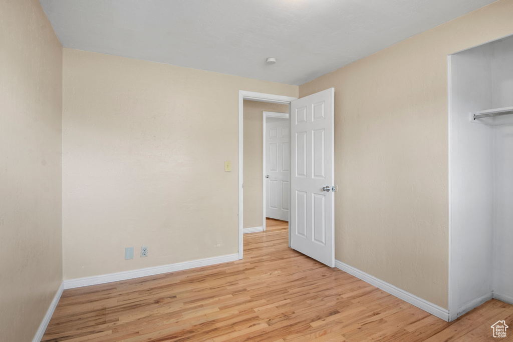 Unfurnished bedroom with baseboards, light wood-style flooring, and a closet