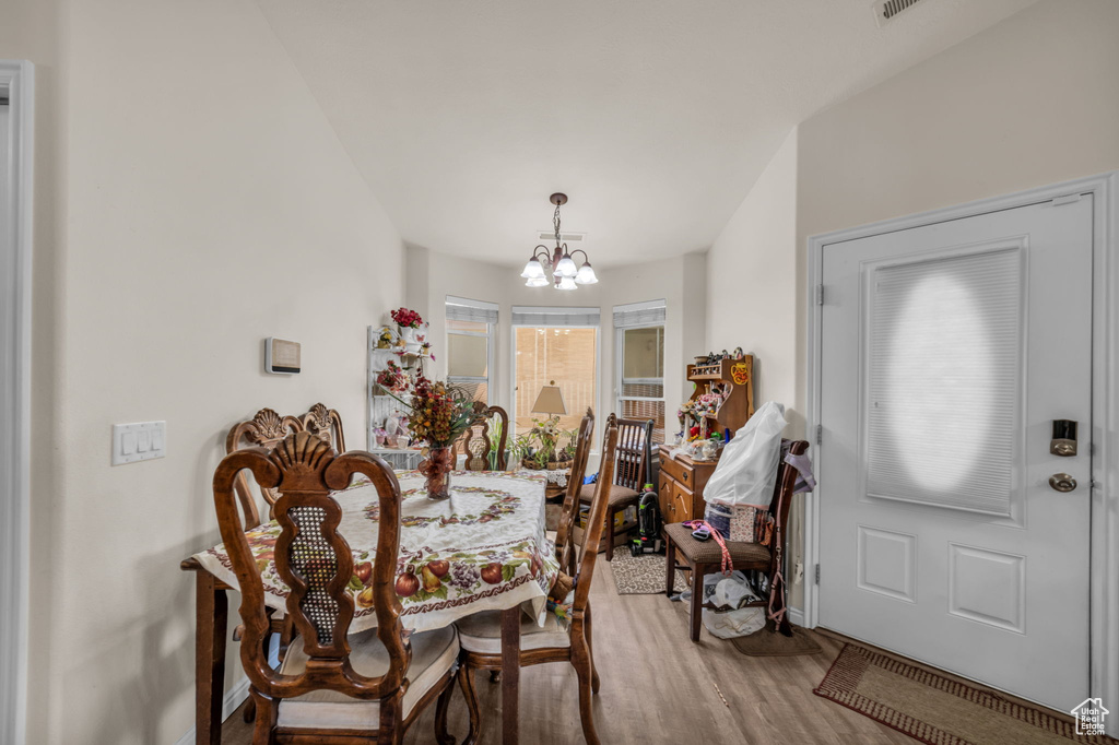 Dining room with baseboards, an inviting chandelier, and wood finished floors