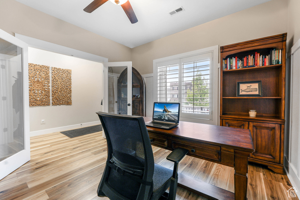 Office area featuring visible vents, a ceiling fan, light wood-style flooring, and baseboards