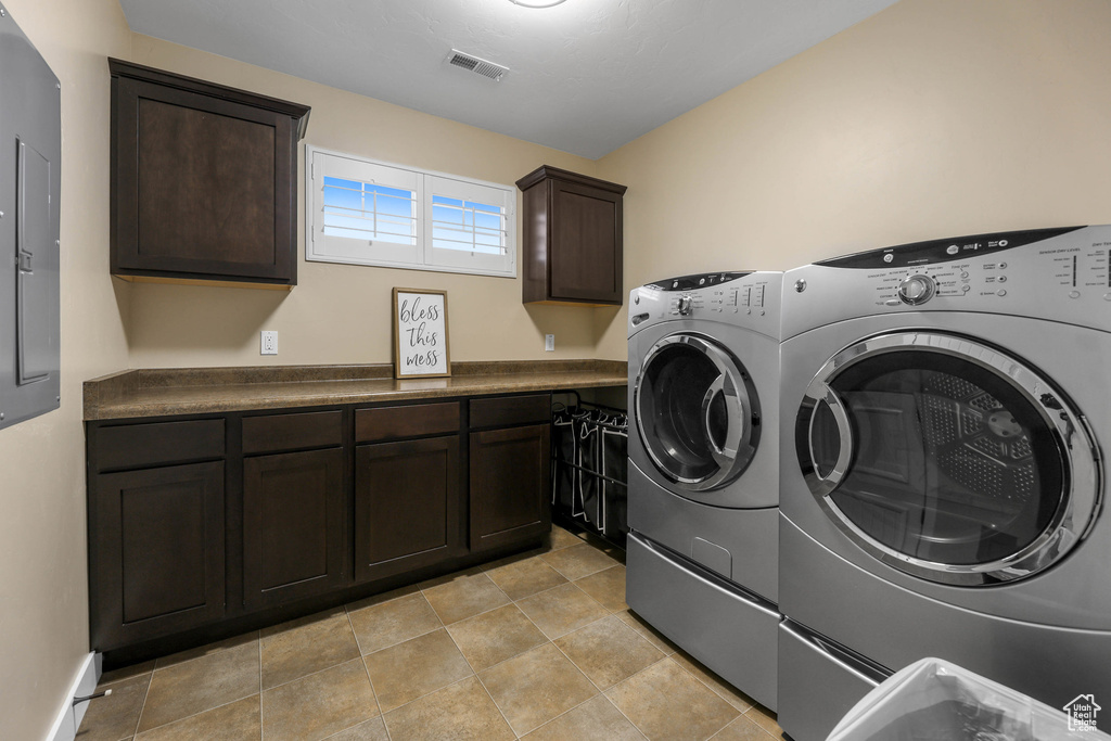Laundry room with cabinet space, visible vents, and washing machine and clothes dryer