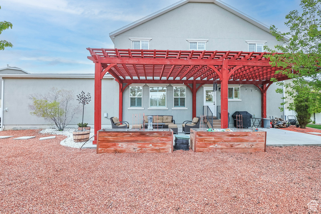 Back of property featuring a pergola, an outdoor living space, and a patio area
