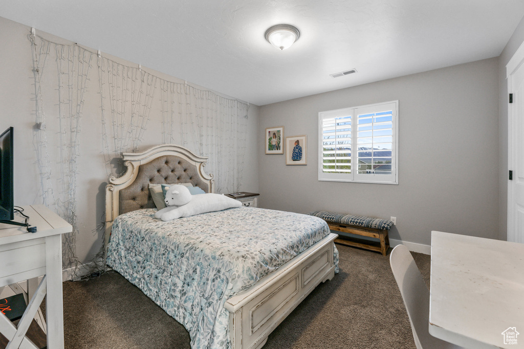 Bedroom with visible vents and dark colored carpet