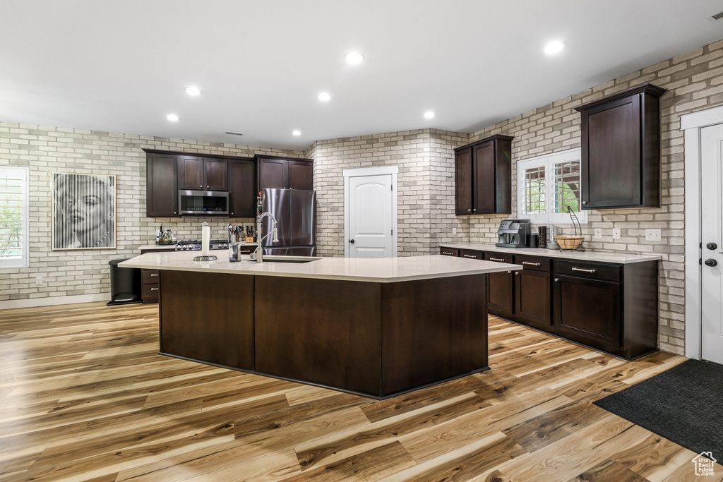 Kitchen featuring light countertops, stainless steel appliances, and dark brown cabinets