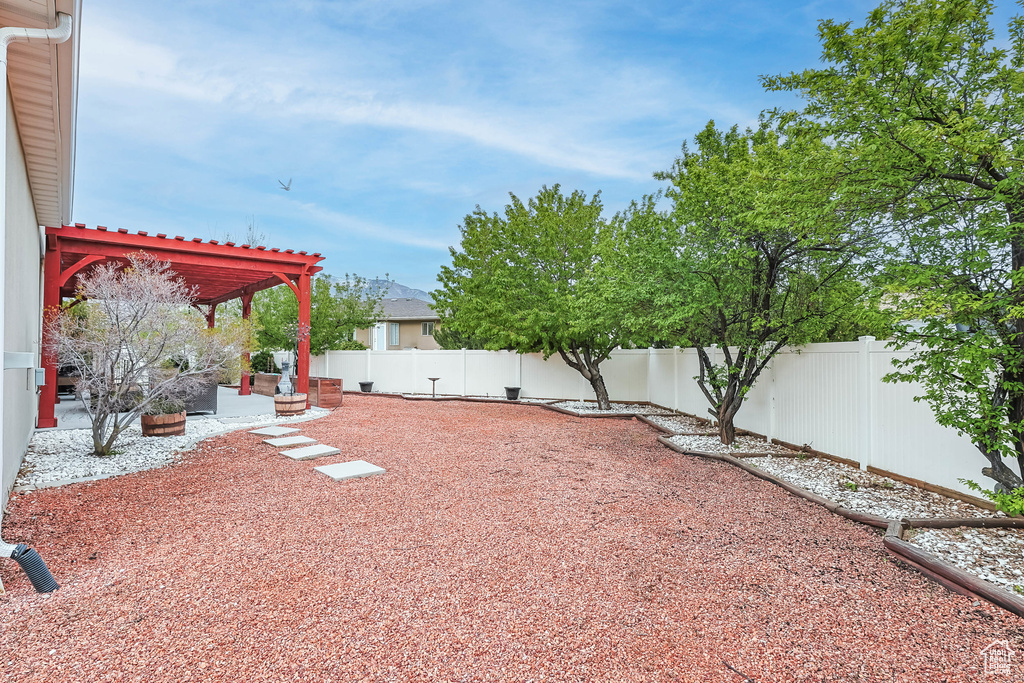 View of yard with a pergola, a fenced backyard, and a patio area