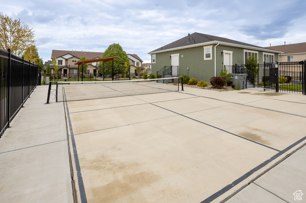Exterior space featuring fence, a tennis court, and a residential view