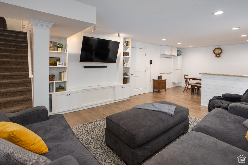 Living area with stairs, recessed lighting, and light wood-style floors