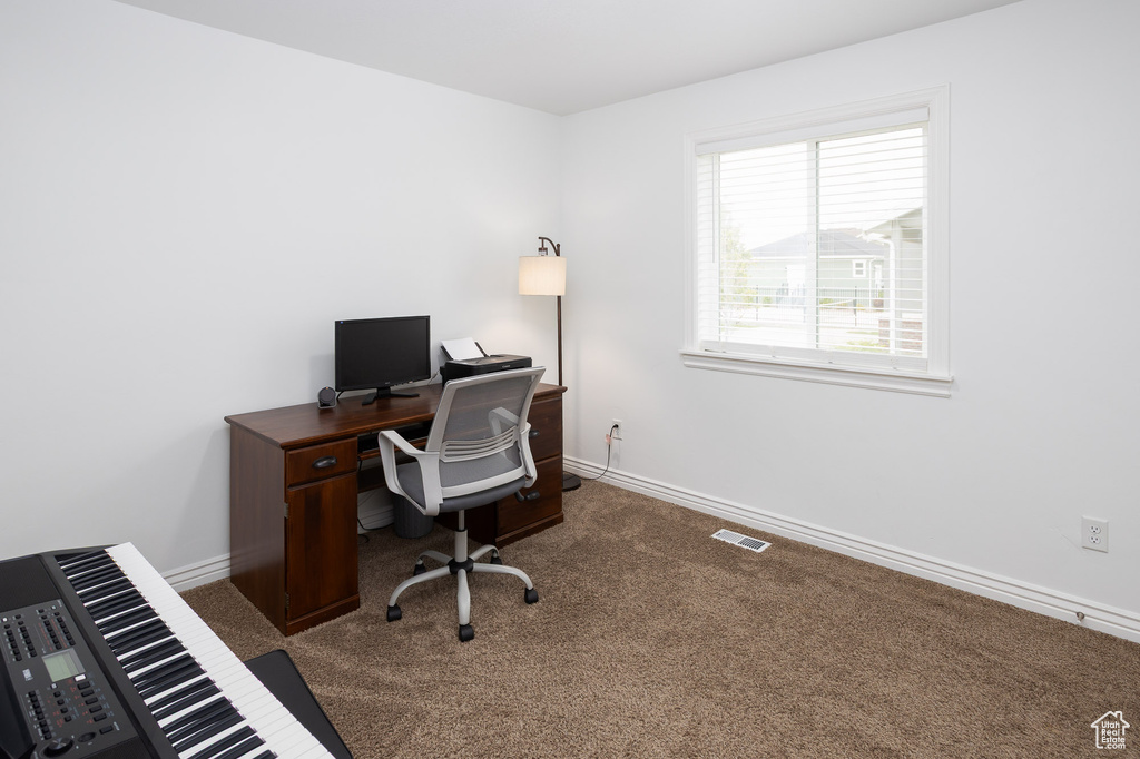 Carpeted office with visible vents and baseboards