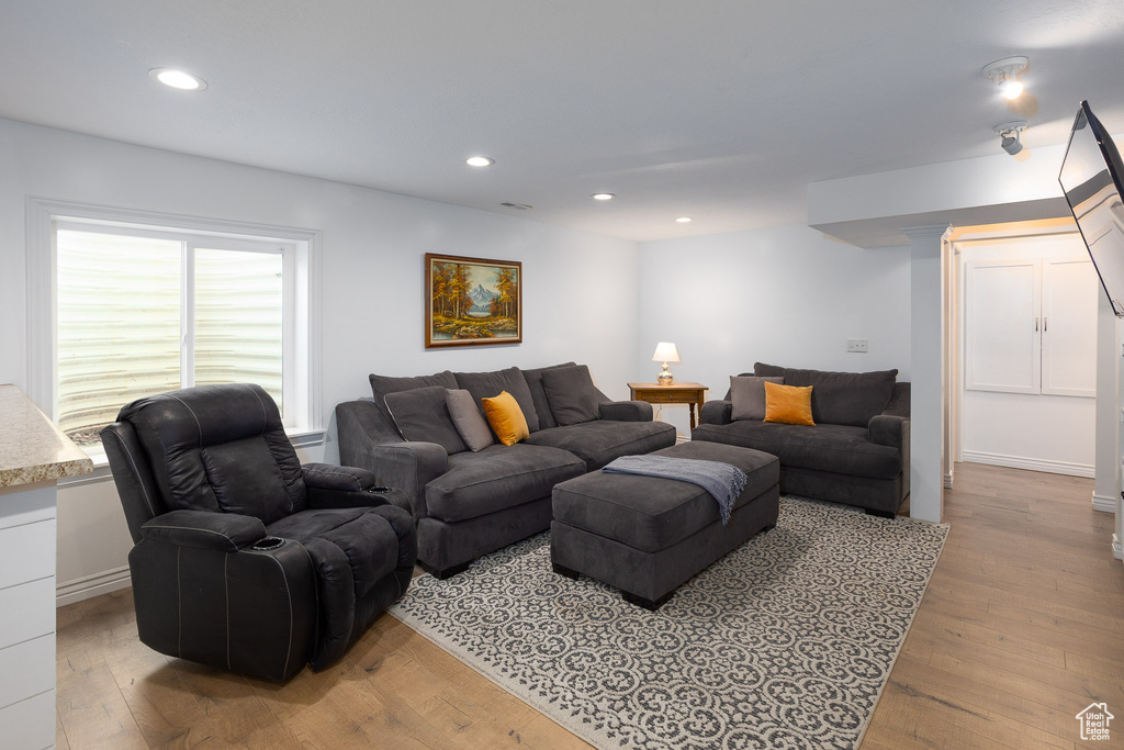 Living room with light wood-style floors and recessed lighting
