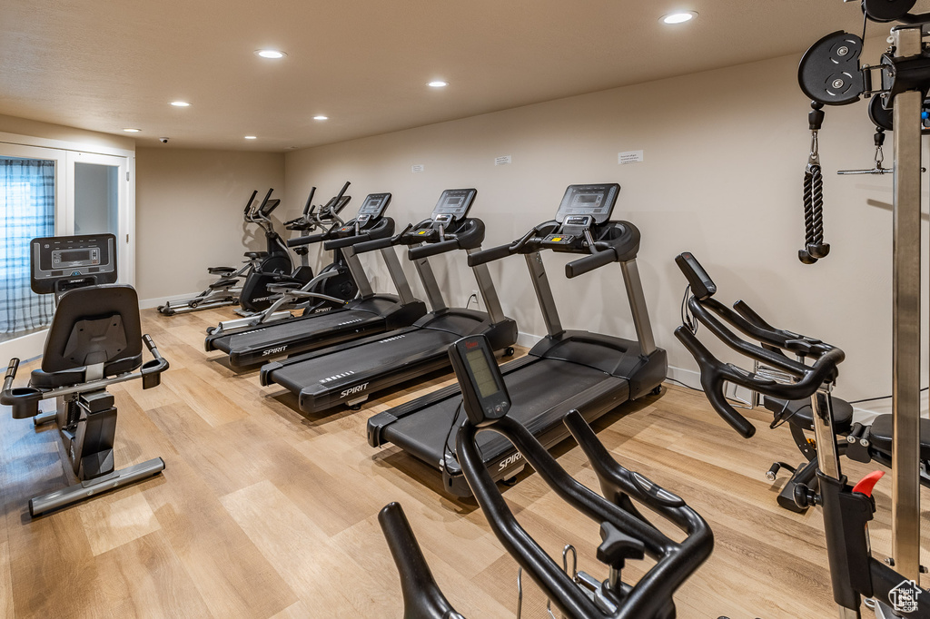 Exercise room with baseboards, recessed lighting, and wood finished floors