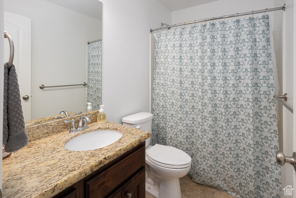 Full bath featuring vanity, tile patterned flooring, curtained shower, and toilet