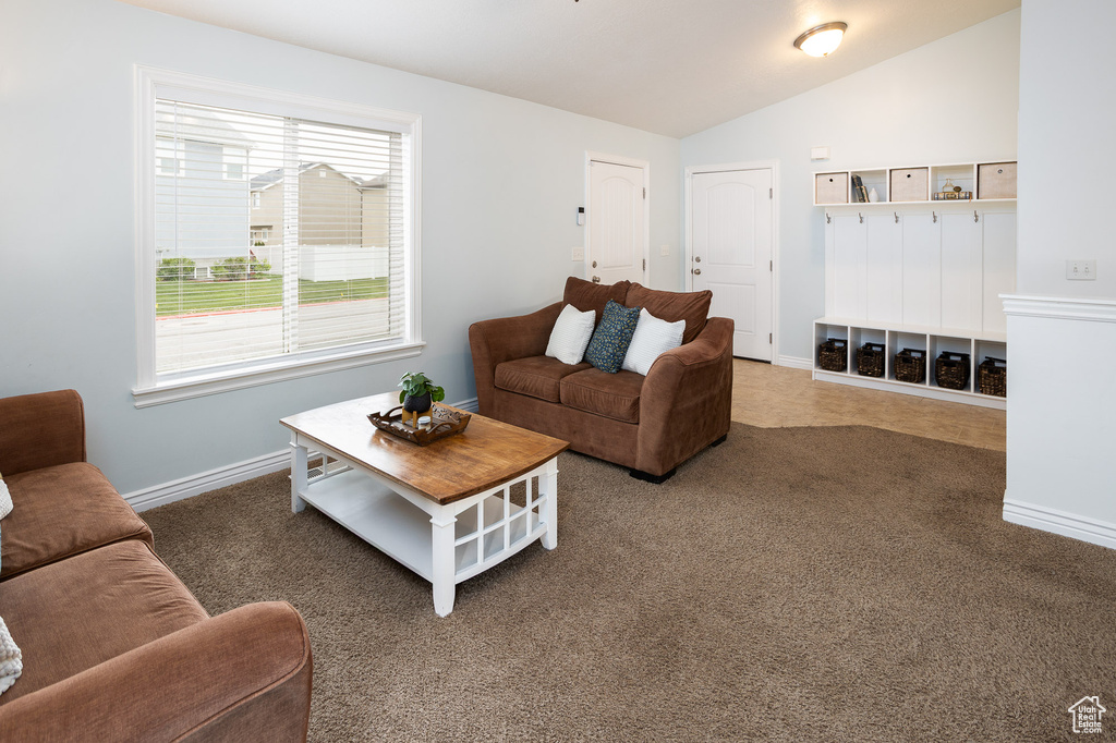 Carpeted living room with baseboards and vaulted ceiling