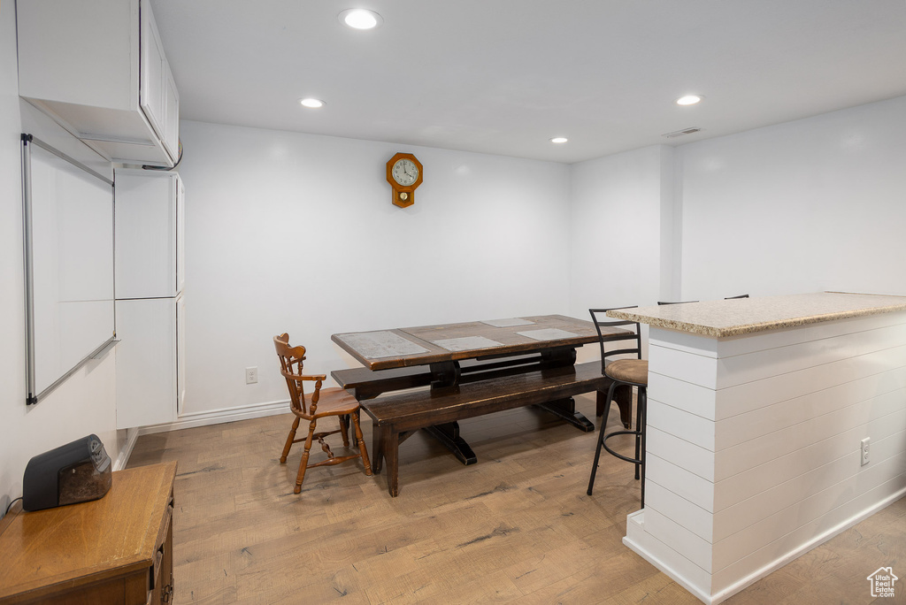 Dining space featuring light wood-style floors, recessed lighting, and visible vents