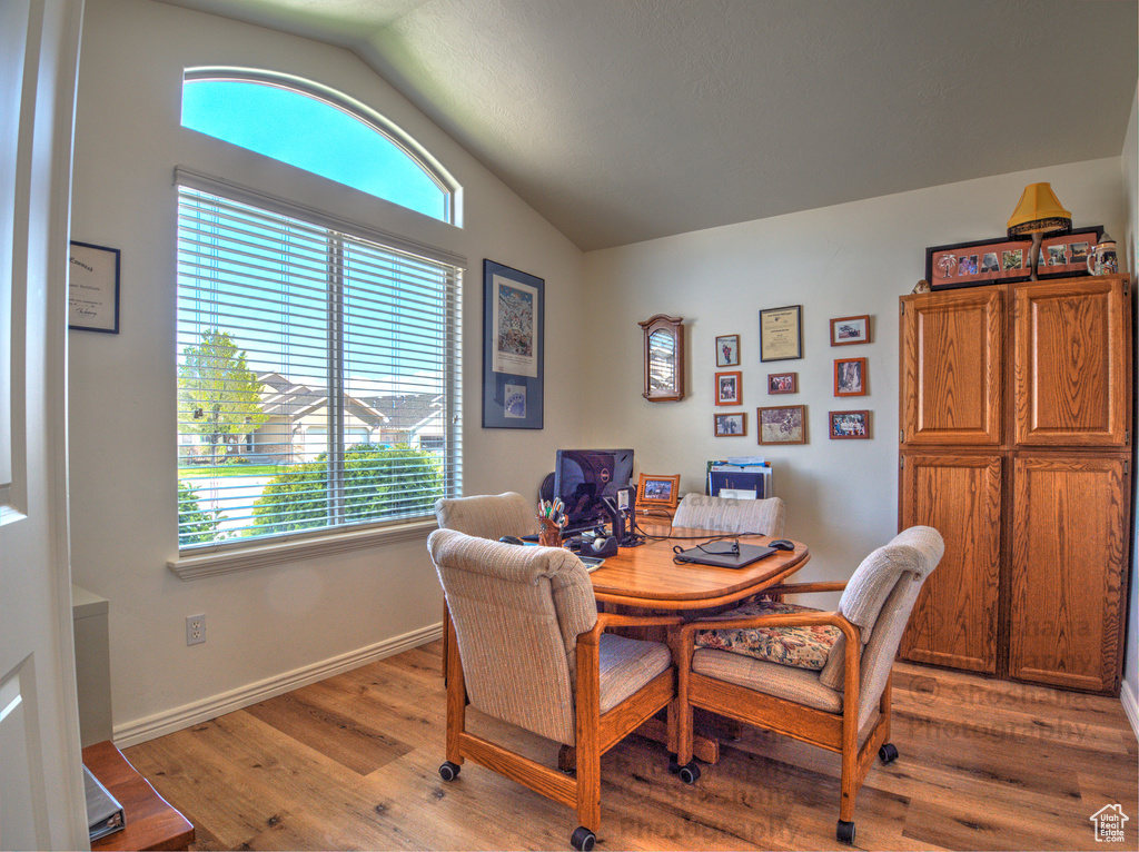 Dining space featuring plenty of natural light, light wood finished floors, and lofted ceiling