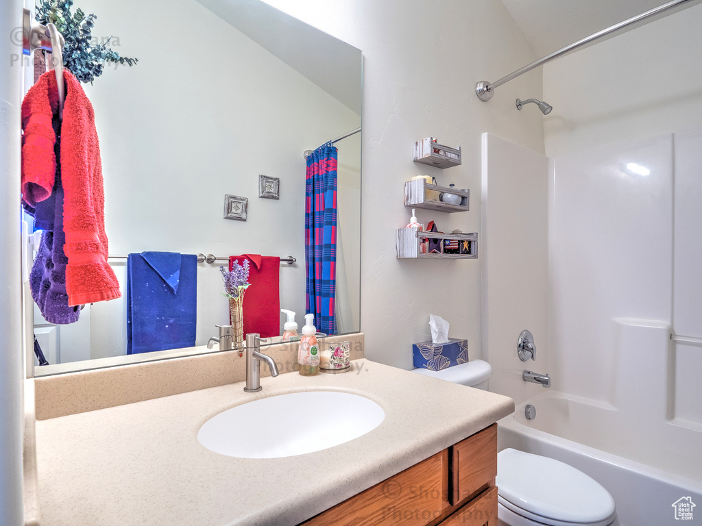 Full bath with vanity, shower / bathtub combination with curtain, and toilet