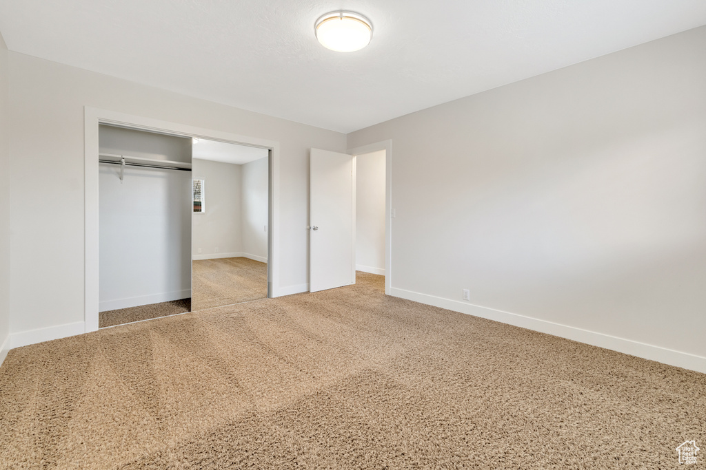 Unfurnished bedroom with baseboards, a closet, and carpet floors