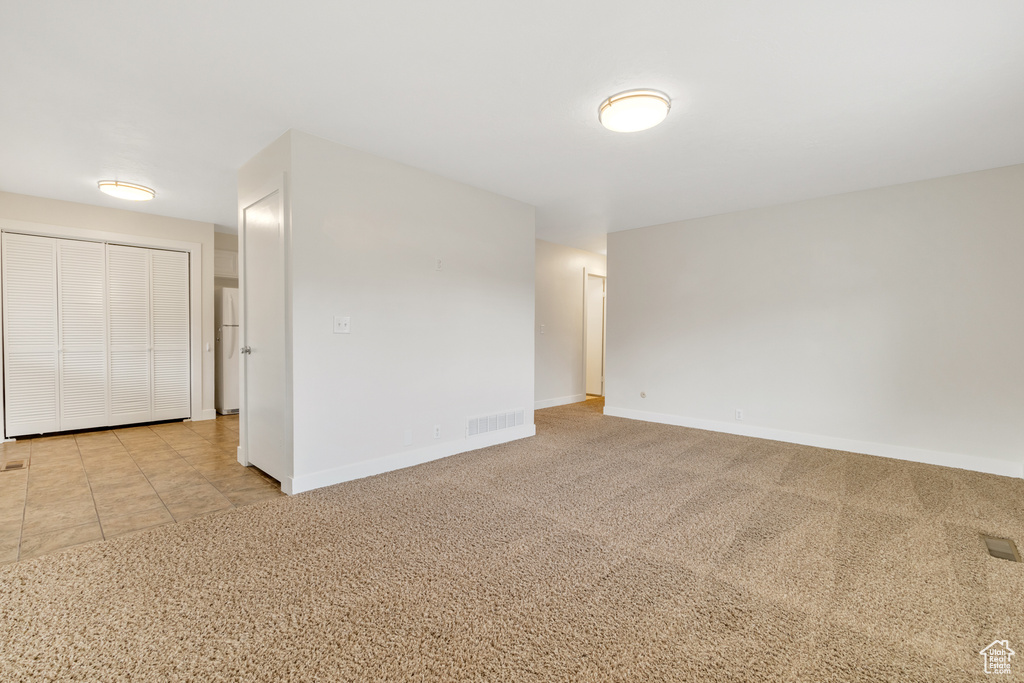 Empty room with baseboards, carpet flooring, and visible vents