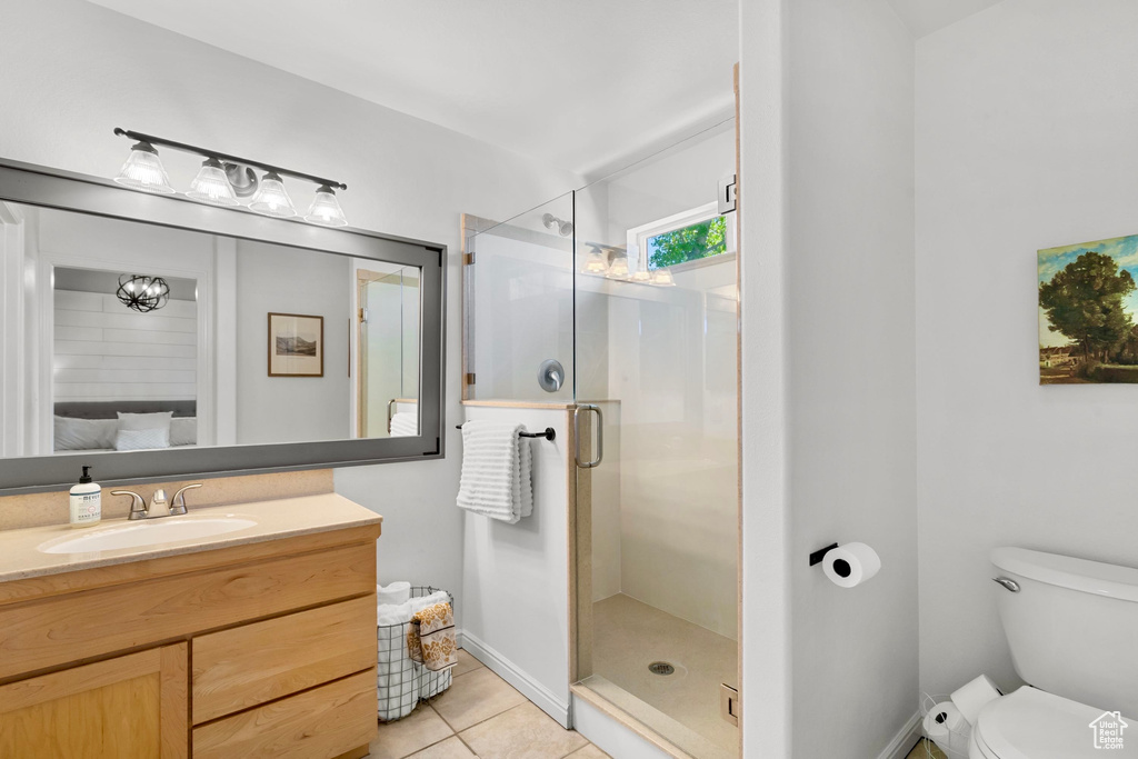 Full bath featuring tile patterned flooring, vanity, toilet, and a shower stall