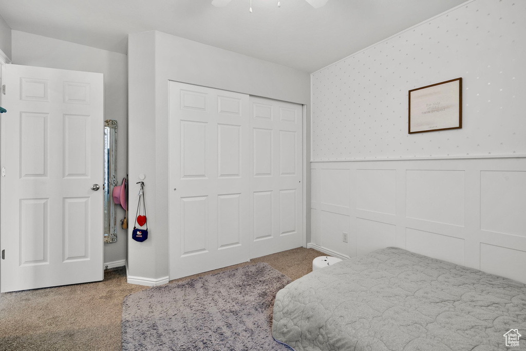 Bedroom with carpet, a decorative wall, a wainscoted wall, and wallpapered walls