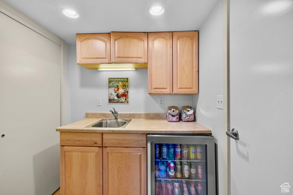 Bar featuring a sink, wet bar, recessed lighting, and beverage cooler