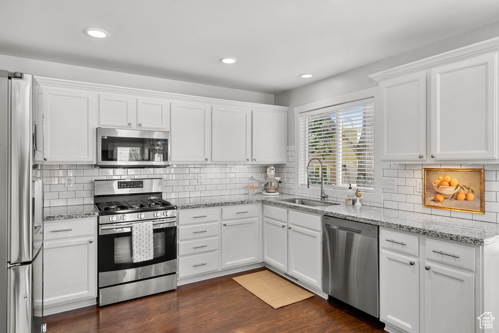 Kitchen featuring a sink, stainless steel appliances, and white cabinetry