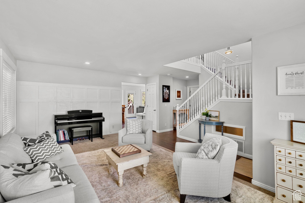 Living room featuring recessed lighting, baseboards, wood finished floors, and stairway