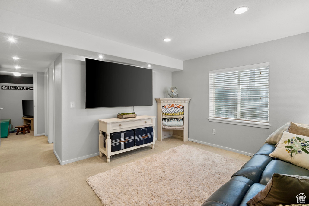 Living room with recessed lighting, baseboards, and light carpet
