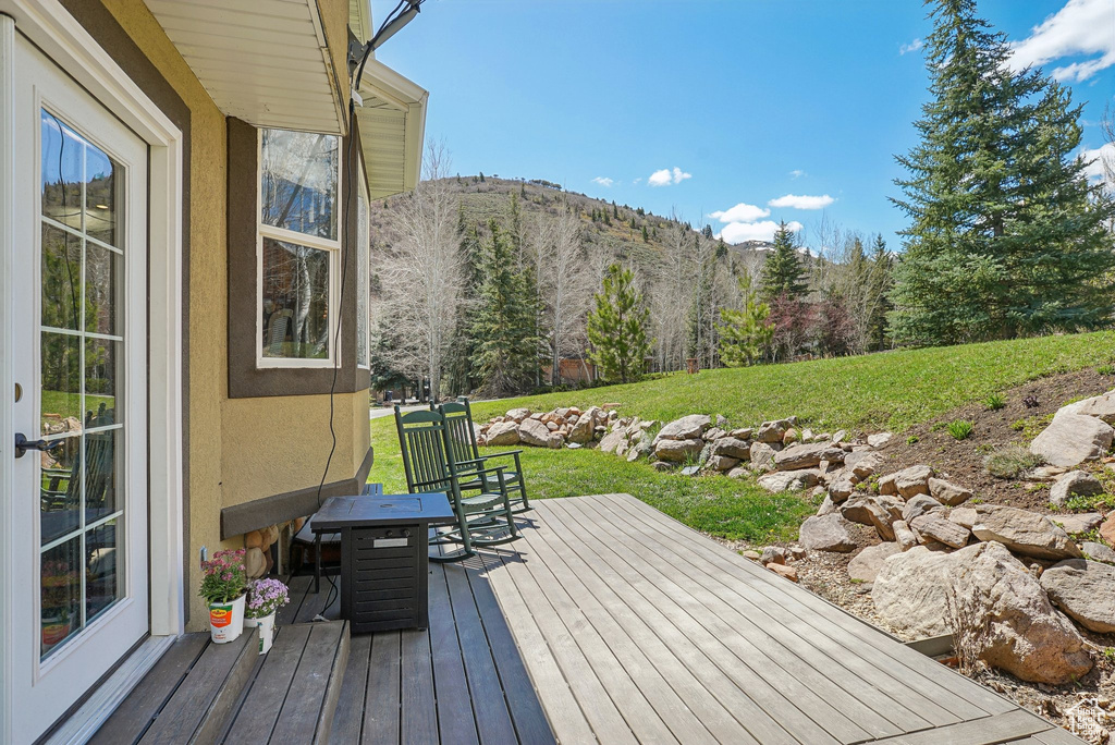 Wooden deck with a lawn and a mountain view