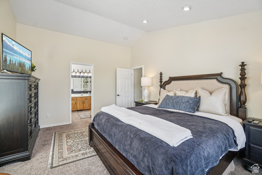 Bedroom with carpet, lofted ceiling, and ensuite bathroom