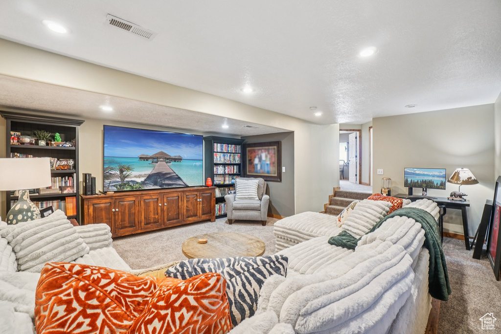Carpeted living room featuring stairway and recessed lighting