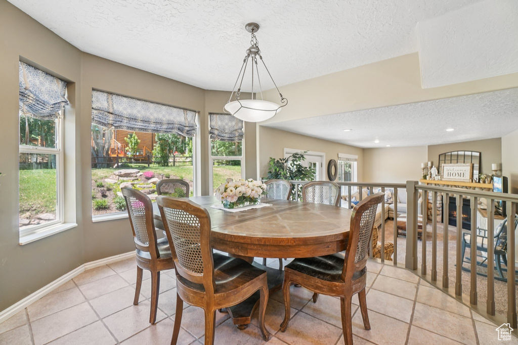 Dining space with a textured ceiling and light tile patterned floors