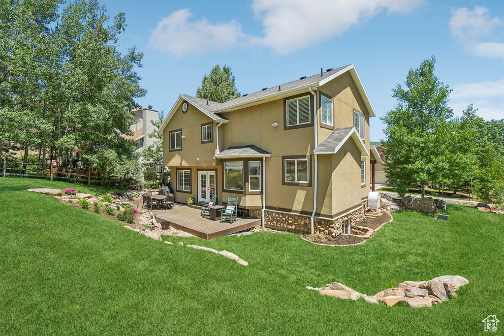 Back of property featuring french doors, stucco siding, a patio area, and a yard