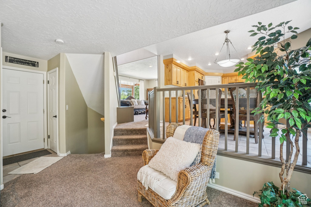 Sitting room with carpet floors, stairway, recessed lighting, and a textured ceiling