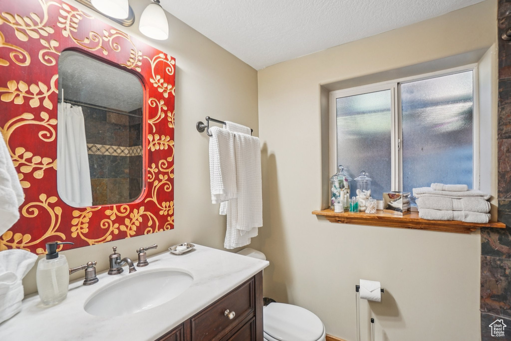 Bathroom with vanity, a shower with curtain, and a textured ceiling