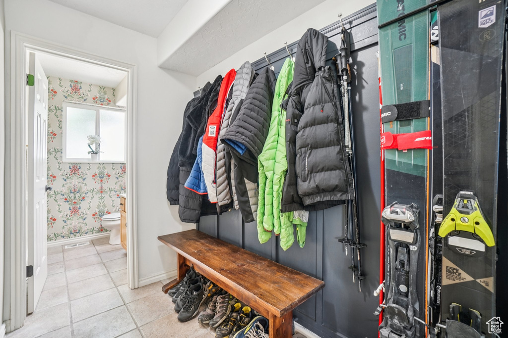 Mudroom featuring tile patterned flooring and wallpapered walls