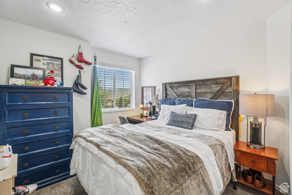 Carpeted bedroom featuring a textured ceiling and recessed lighting