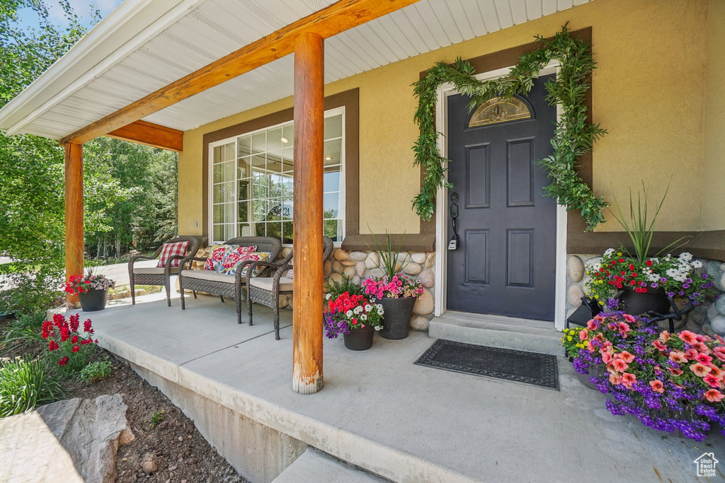 Property entrance with a porch and stucco siding