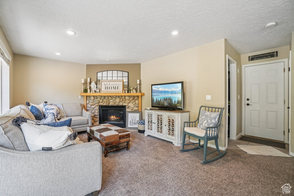 Living area featuring carpet, a fireplace, a textured ceiling, and recessed lighting