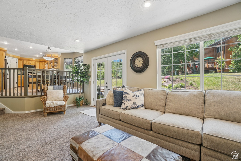 Living room with french doors, recessed lighting, healthy amount of natural light, a textured ceiling, and carpet