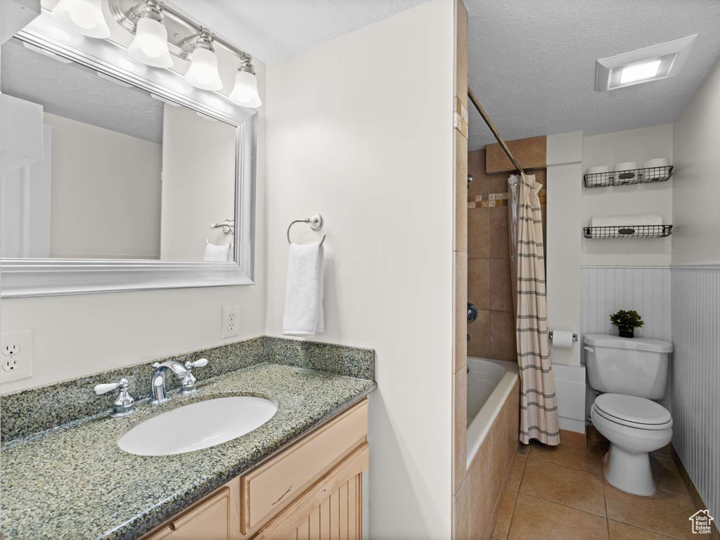 Full bathroom with vanity, tile patterned flooring, toilet, and shower / tub combo with curtain