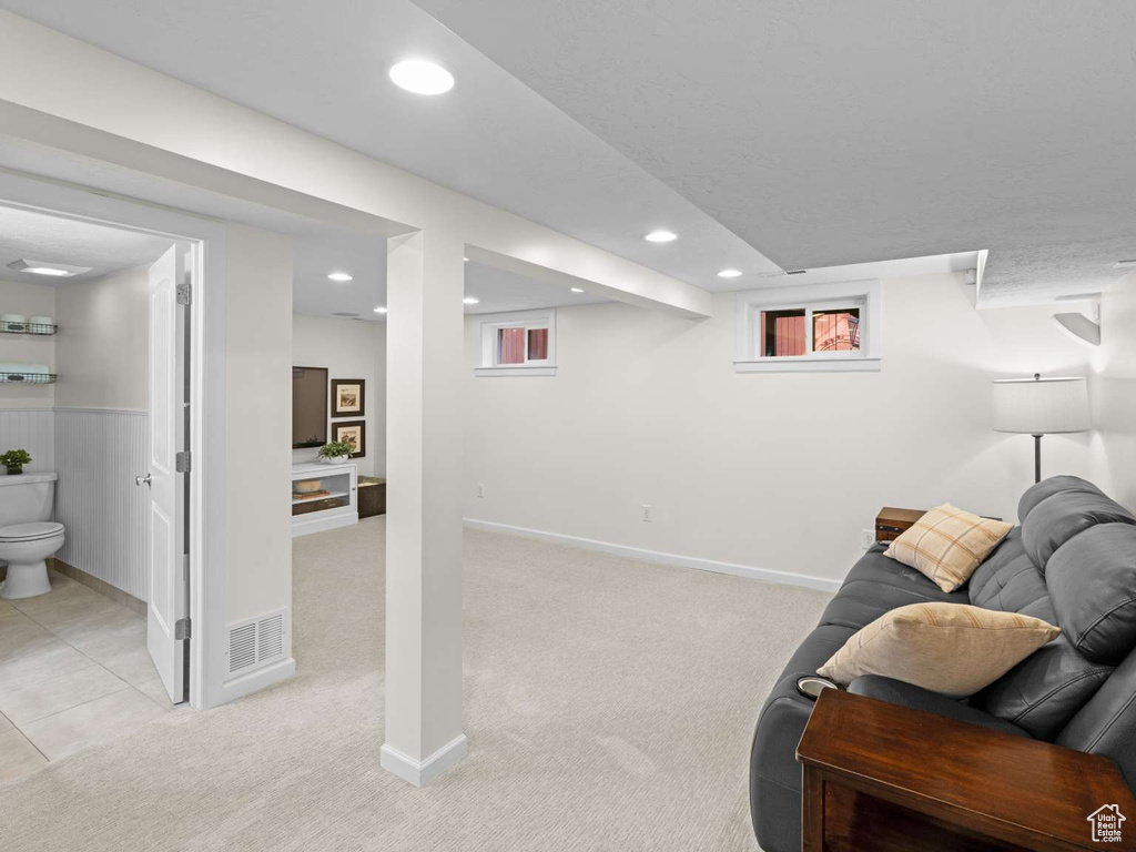 Living room with baseboards, visible vents, recessed lighting, and light colored carpet