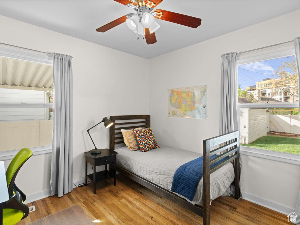 Bedroom featuring baseboards, a ceiling fan, and wood finished floors